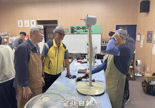 이억만 강사와 시민들이 가져온 선풍기를 살펴보며 고장 부위와 원인을 진단 중이다. /이상구 수습기자
