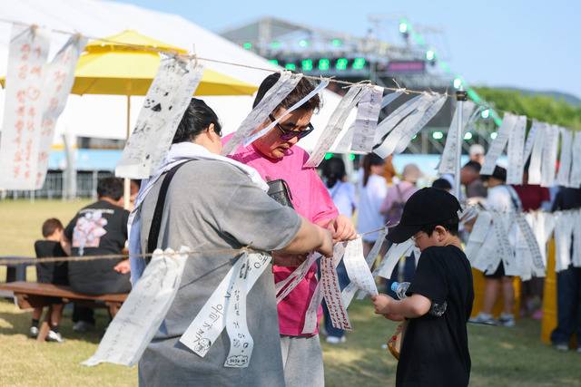 '2026 성주참외&생명문화축제'에 참가한 가족이 온가족 행복을 기원하는 소원지를 붙이고 있다. 성주군 제공