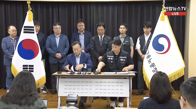 여명구 삼성전자 DS(디바이스솔루션, 반도체) 피플팀장(부사장)과 최승호 초기업노동조합 삼성전자 지부 위원장이 잠정합의에 대한 서명을 진행 중이다.(유튜브 연합뉴스TV 캡처)