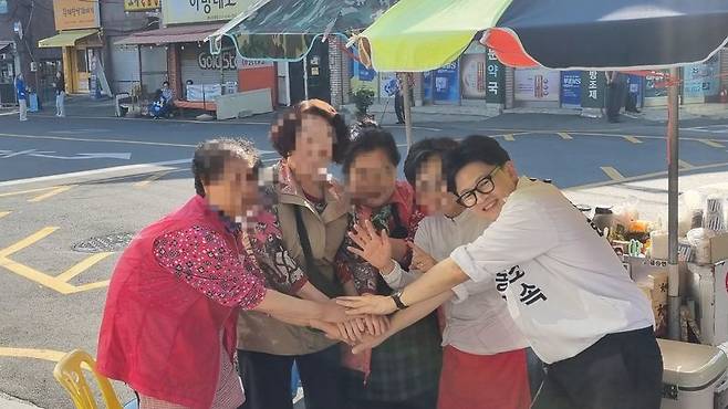 한동훈 후보가 19일 부산 북구 구포동 일대에서 지지자들과 함께 포즈를 취하고 있다. 사진=이해람 기자