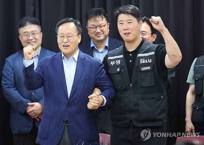 삼성전자 파업 유보 (수원=연합뉴스) 홍기원 기자 = 20일 경기도 수원시 장안구 경기고용노동청에서 열린 삼성전자 임금협상을 마친 후 여명구 삼성전자 DS(디바이스솔루션·반도체 사업 담당) 피플팀장과 최승호 삼성그룹 초기업노동조합 삼성전자지부 위원장이 잠정 합의안에 서명한 후 파이팅을 외치고 있다. 2026.5.20 xanadu@yna.co.kr