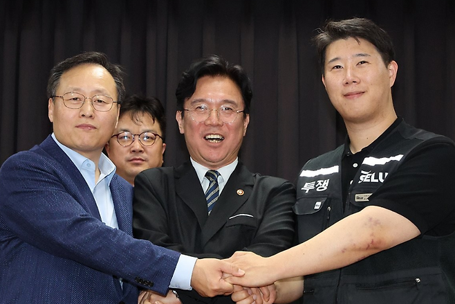 20일 경기도 수원시 장안구 경기고용노동청에서 열린 삼성전자 임금협상을 마친 후 여명구 삼성전자 DS(디바이스솔루션·반도체 사업 담당) 피플팀장과 최승호 삼성그룹 초기업노동조합 삼성전자지부 위원장이 잠정 합의안에 서명한 후 손을 맞잡고 있다. / 사진=연합뉴스