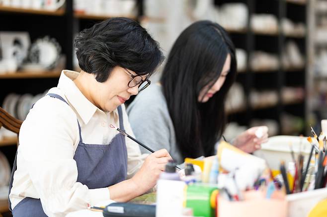 도도세라믹 김선희 작가가 딸 이빛나 씨와 함께 도자기 위에 그림을 그리며 제품 작업을 하고 있다.(이준호 기자)