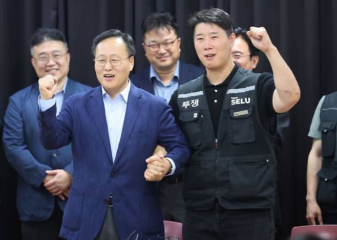20일 경기도 수원시 장안구 경기고용노동청에서 열린 삼성전자 임금협상을 마친 후 여명구 삼성전자 DS(디바이스솔루션·반도체 사업 담당) 피플팀장과 최승호 삼성그룹 초기업노동조합 삼성전자지부 위원장이 잠정 합의안에 서명한 후 파이팅을 외치고 있다. 연합뉴스.