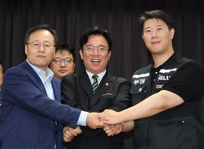 20일 경기 수원시 장안구 경기고용노동청에서 열린 삼성전자 임금협상을 마친 후 여명구 삼성전자 DS(디바이스솔루션·반도체 사업 담당) 피플팀장(왼쪽부터)과 김영훈 고용노동부 장관, 최승호 삼성그룹 초기업노동조합 삼성전자지부 위원장이 잠정 합의한에 서명한 후 손을 맞잡고 있다./뉴스1