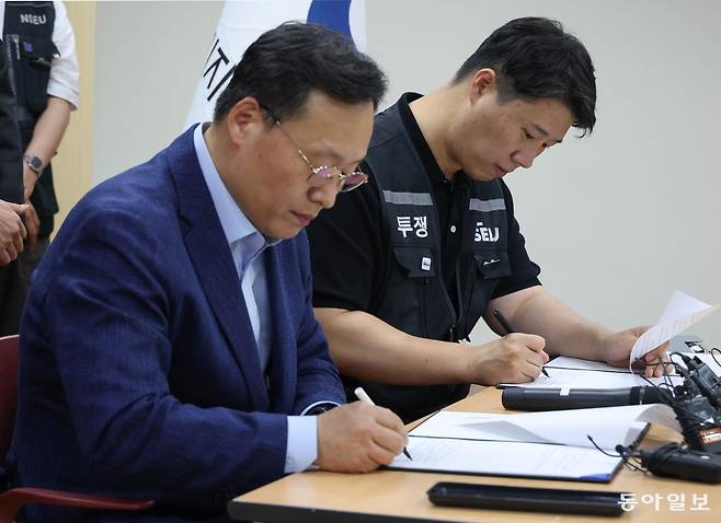 여명구 삼성전자 DS(디바이스솔루션·반도체 사업 담당) 피플팀장(왼쪽)과 최승호 삼성그룹 초기업노동조합 삼성전자지부 위원장이 20일 오후 경기 수원시 장안구 경기지방고용노동청에서 열린 삼성전자 노사교섭 결과 브리핑에서 합의안에 서명을 하고 있다. 2026.05.20 수원=양회성 기자 yohan@donga.com