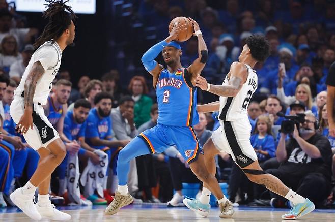 미국 프로농구(NBA) 오클라호마시티 썬더의 샤이 길저스알렉산더(가운데)가 샌안토니오 스퍼스 수비수를 뚫고 공격을 시도하고 있다. 연합뉴스