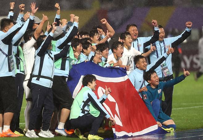 북한 내고향여자축구단 선수들이 20일 수원종합운동장에서 열린 수원FC위민과 2025~2026 아시아축구연맹(AFC) 여자 챔피언스리그 4강전에서 이긴 뒤 인공기를 펼치고 기뻐하고 있다. 수원 | 연합뉴스