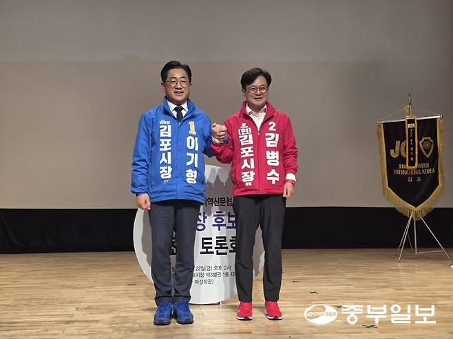 더불어민주당 이기형 후보와 국민의 힘 김병수 후보가 손을 맞잡고 포즈를 취하고 있다. 천용남