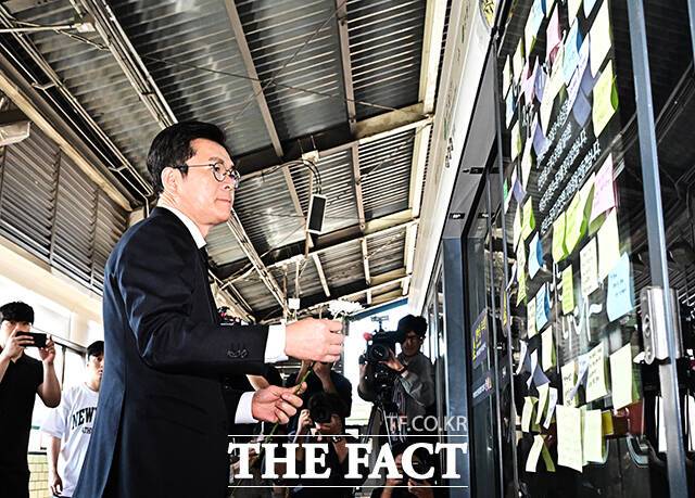 정원오 더불어민주당 서울시장 후보가 22일 오전 서울 광진구 구의역 9-4 승강장에서 구의역 참사 10주기 추모 헌화 전 메모를 부착하고 있다. /배정한 기자