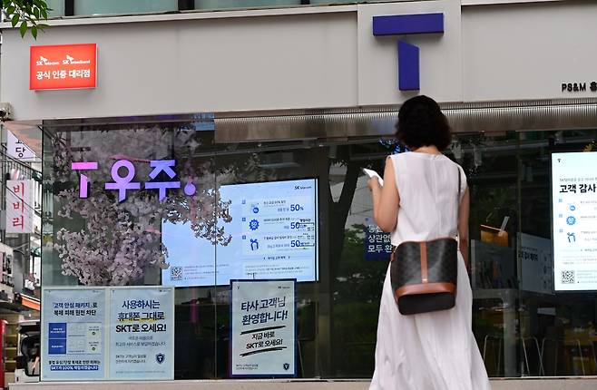 서울 시내의 한 SK텔레콤 대리점 앞에 시민들이 지나고 있다. 이상섭 기자