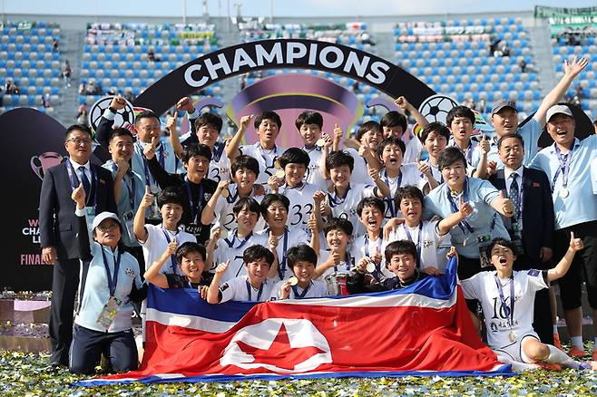 내고향여자축구단이 23일 수원 장안구 수원종합운동장에서 열린 아시아축구연맹(AFC) 여자 챔피언스리그(AWCL) 시상식에서 인공기를 들고 우승 기념촬영을 하고 있다. 연합뉴스