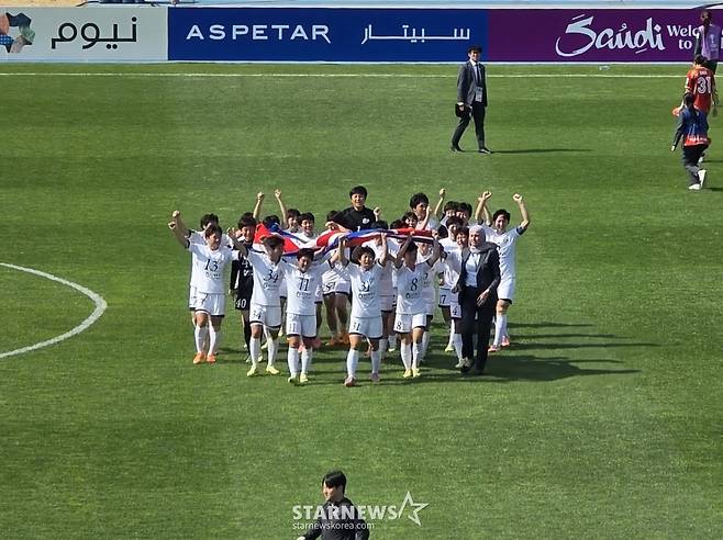 23일 수원종합운동장에서 열린 내고향축구단과 도쿄 베르디 벨레자의 2025-2026 아시아축구연맹(AFC) 여자 챔피언스리그 결승전. 우승을 확정한 내고향 선수들이 대형 인공기를 든 채 경기장을 돌고 있다. /사진=김명석 기자
