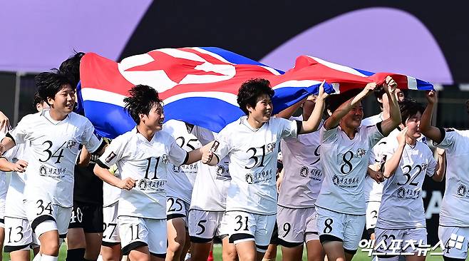 북한 내고향여자축구단 23일 오후 수원종합운동장에서 열린 2025-2026시즌 아시아축구연맹(AFC) 여자 챔피언스리그(AWCL) 결승전에서 일본 도쿄 베르디에 1-0으로 이긴 뒤 시상식에서 북한 국기인 인공기를 펼쳐든 채 우승 세리머니를 하고 있다. 내고향은 전신인 AFC 여자 클럽 챔피언십을 포함해 이 대회에서 북한 팀으로는 처음으로 정상에 올랐다. 수원, 박지영 기자