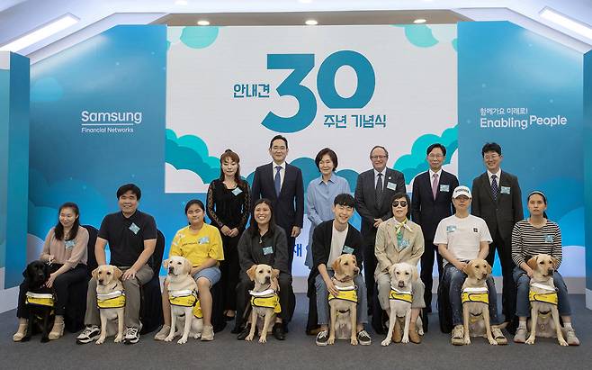 2023년 9월 19일 경기 용인시 삼성화재 안내견학교에서 열린 설립 30주년 기념식에서 이재용 삼성전자 회장(뒷줄 왼쪽에서 두 번째)이 안내견을 분양받은 시각장애인 파트너(앞줄) 등과 기념사진을 찍고 있다. 삼성전자 제공