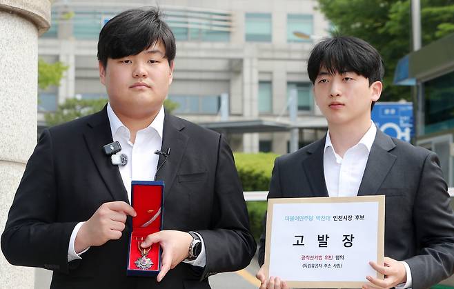 ▲ 29일 인천 남동구 인천경찰청 앞에서 독립유공자 박진해 선생 직계 5대손 박기현씨가 더불어민주당 박찬대 인천시장 후보를 고발하기에 앞서 독립유공자 건국훈장을 공개하고 있다. /사진제공=정복캠프