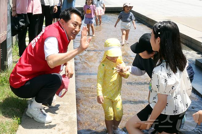 오세훈 국민의힘 서울시장 후보가 30일 오후 서울 영등포구 여의도 한강공원을 찾아 어린이에게 인사하고 있다. 2026.5.30 ⓒ 뉴스1 김진환 기자