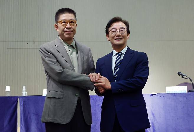 더불어민주당 전재수(오른쪽) 부산시장 후보와 국민의힘 박형준 부산시장 후보가 26일 오전 부산 해운대구 동서대학교 센텀캠퍼스에서 열린 관훈클럽·부산일보 주최 관훈토론회에서 손을 맞잡고 있다. 연합뉴스