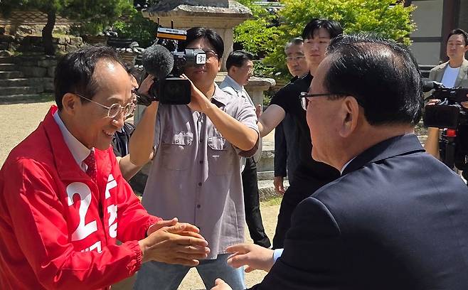 김부겸 더불어민주당 대구시장 후보와 추경호 국민의힘 대구시장 후보가 부처님오신날인 지난 24일 대구 대표 사찰인 동화사에서 열린 봉축법요식에 참석하기에 앞서 마주쳐 인사를 나누고 있다. 뉴스1