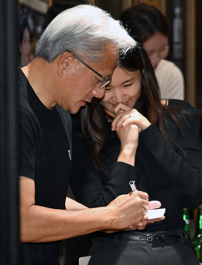 젠슨 황 엔비디아 최고경영자(CEO)가 30일 오후 서울 강남구 삼성역 인근 깐부치킨 매장에서 이재용 삼성그룹 회장, 정의선 현대차그룹 회장과 치킨 회동 중 시민들에게 사인을 해주고 있다. 신태현 기자 holjjak@