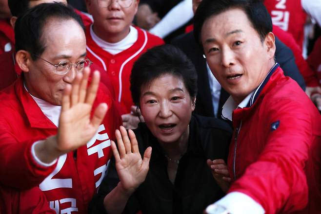 박근혜(가운데) 전 대통령이 지난달 31일 추경호(왼쪽) 국민의힘 대구시장 후보, 유영하 국민의힘 의원과 함께 대구 수성구 수성못을 찾아 시민들에게 손 인사를 건네고 있다. 대구=뉴스1