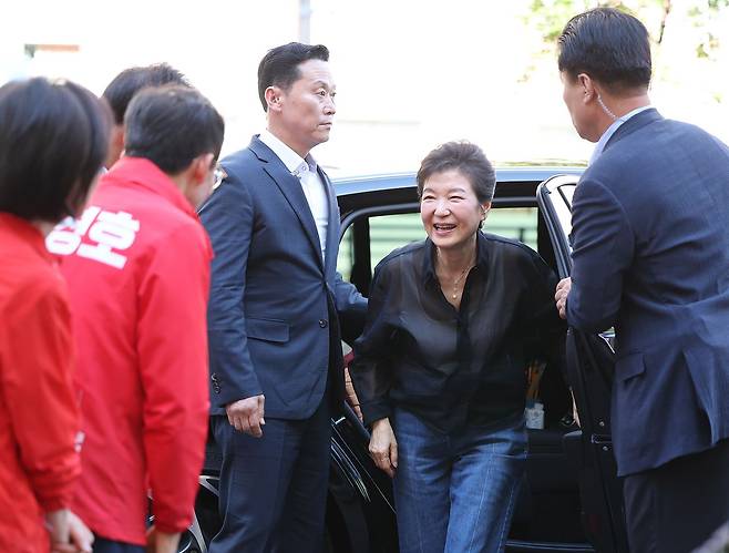 박근혜 전 대통령이 31일 오후 대구 중구 서문시장을 찾아 차량에서 내리며 추경호 국민의힘 대구시장 후보와 인사하고 있다. 뉴스1