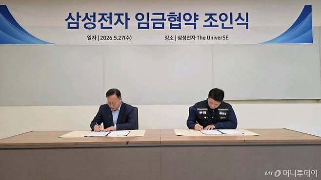 (서울=뉴스1) = 여명구 삼성전자 DS부문 피플팀장 부사장(왼쪽)과 최승호 삼성그룹 초기업노동조합 삼성전자지부 위원장이 27일 경기 용인시 삼성전자 The UniverSE에서 진행된 2026년 삼성전자 임금협약 조인식에서 서명을 하고 있다. (삼성그룹 초기업 노동조합 삼성전자지부 제공. 재판매 및 DB 금지) 2026.5.27/뉴스1 Copyright (C) 뉴스1. All rights reserved. 무단 전재 및 재배포, AI학습 이용 금지. /사진=(서울=뉴스1)