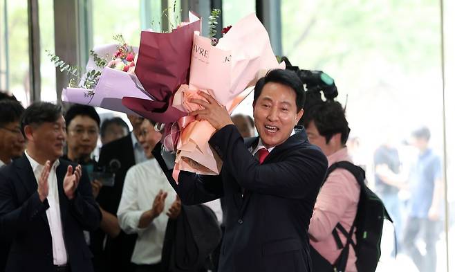 오세훈 서울특별시장 당선인이 4일 서울시청으로 들어서며 직원들에게 받은 꽃다발을 들고 기뻐하고 있다. 최현규 기자