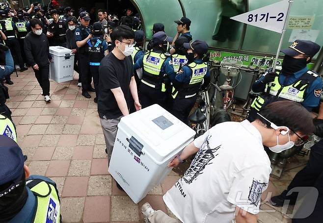 5일 '투표용지 부족' 사태가 발생한 서울 송파구 잠실7동 제2투표소 앞에서 서울시선관위 관계자들이 투표함을 이송하고 있다. 2026.6.5 ⓒ 뉴스1 김도우 기자