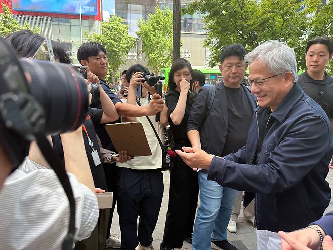 젠슨 황 엔비디아 최고경영자(CEO)가 5일 오후 서울 마포구에 있는 T1이 운영하는 e스포츠 PC방 ‘T1 베이스캠프’를 찾아 시민들과 인사하고 있다./최은경 기자