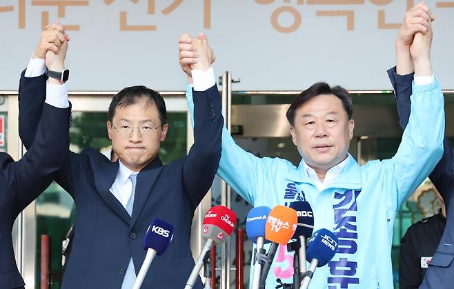 지난달 28일 울산시 중구 울산시선거관리위원회 앞에서 더불어민주당 김상욱(왼쪽), 진보당 김종훈 울산시장 후보가 김상욱 후보로의 단일화를 선언하고 함께 손을 잡고 인사하고 있다. 연합뉴스