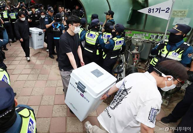 (서울=뉴스1) 김도우 기자 = 5일 '투표용지 부족' 사태가 발생한 서울 송파구 잠실7동 제2투표소 앞에서 서울시선관위 관계자들이 투표함을 이송하고 있다. 2026.6.5/뉴스1 Copyright (C) 뉴스1. All rights reserved. 무단 전재 및 재배포, AI학습 이용 금지. /사진=(서울=뉴스1) 김도우 기자