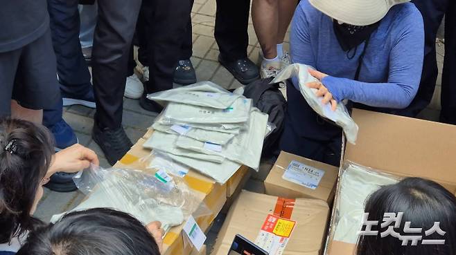 5일 개표소 앞에서 부정선거를 주장하는 시위대들이 대한체육회 측의 택배상자를 개봉해 내용물을 살펴보고 있다. 송선교 기자.
