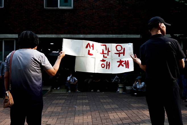 6월4일 제9회 전국동시지방선거 및 국회의원 재·보궐선거 투표용지 부족으로 투표 시간이 오후 10시까지 연장됐던 서울 송파구 잠실7동 제2투표소 앞에서 투표함 반출에 반대하는 시민들이 손팻말을 들고 있다. ⓒ연합뉴스