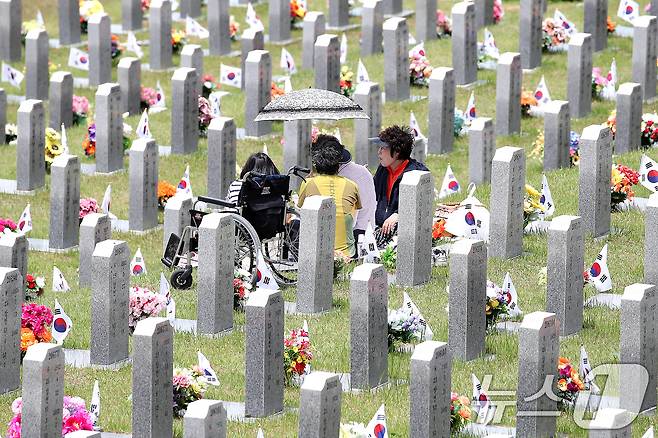 현충일을 하루 앞둔 5일 경북 영천시 고경면 국립영천호국원을 찾은 시민들이 양산으로 뙤약볕을 가린 채 참배하고 있다. 2026.6.5 ⓒ 뉴스1 공정식 기자