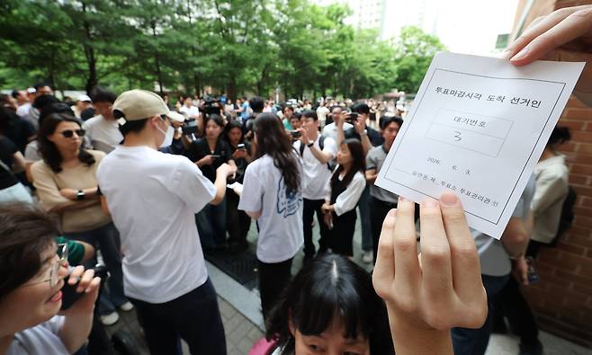 스3 지방선거 본투표일인 3일 투표용지 부족으로 대기하던 한 유권자가 마감시간 후 대기번호표를 들어 보이고 있다./ 연합뉴스