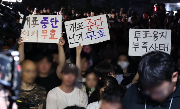 ▲지난 4일 제9회 전국동시지방선거 및 국회의원 재·보궐선거 투표용지 부족으로 투표 시간이 오후 10시까지 연장됐던 서울 송파구 잠실7동 제2투표소 앞에서 '부정선거' 등 손팻말을 든 시민들이 구호를 외치고 있다. ⓒ연합뉴스