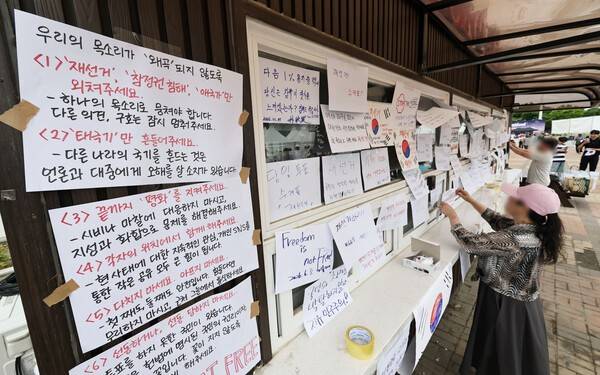 6·3 지방선거 투표지 부족 사태를 규탄하며 재선거를 요구하는 '잠실 개표소 봉쇄 시위'가 계속되고 있는 7일 서울 송파구 올림픽공원 핸드볼경기장 앞 매표소 부스에 재선거를 요구하는 문구 등이 적힌 종이가 붙어있다. 연합뉴스