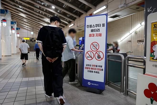 한 승객이 지하철 역사 내 비치된 배터리 반입 관련 안내문을 보고 있다.