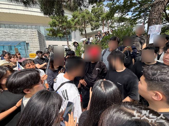 8일 집회 참가자들이 한 20대 남성을 둘러싸며 해명을 요구하고 있따. 박인 기자
