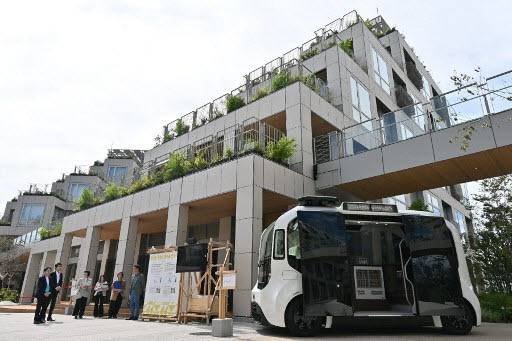 토요타의 실증도시 ‘우븐 시티’ 중앙 광장에 자율주행 전기 e-팔레트가 운행을 준비하고 있다.(사진=AFP)