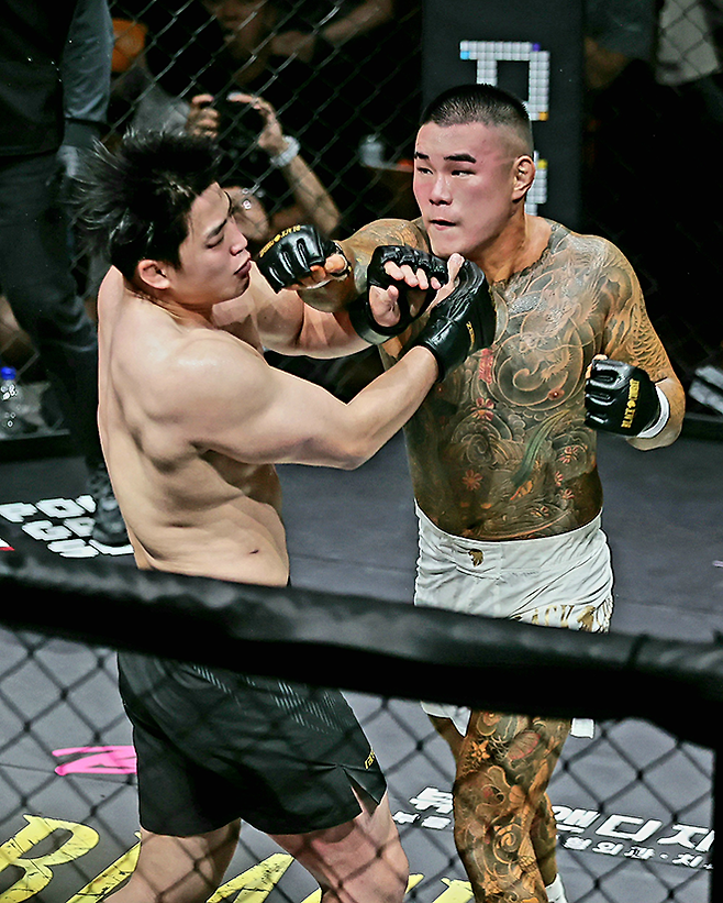 ‘세비지’ 홍희원이 2026년 6월 경기도 오산시 종합격투기대회 블랙컴뱃 라이즈 09에서 ‘알밤’ 이종구를 때리고 있다. 홍희원은 대한복싱협회 전국복싱우승권 은메달, 이종구는 전국체전 레슬링 금메달 및 주짓수 아시아선수권 은메달이다. 사진=이교덕 격투기 전문기자 제공