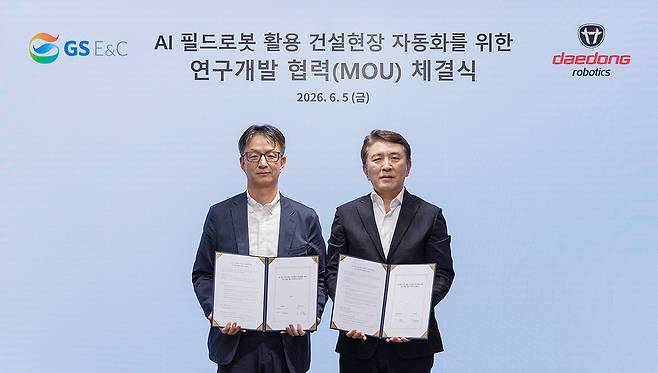 강성철(오른쪽) 대동로보틱스 대표와 조성한 GS건설 부사장이 지난 5일 ‘건설현장 자동화 및 스마트 건설 기술 분야 공동 연구개발 협력을 위한 업무협약(MOU)’에서 양해각서를 들고 기념 촬영을 하고 있다. 사진 제공=대동