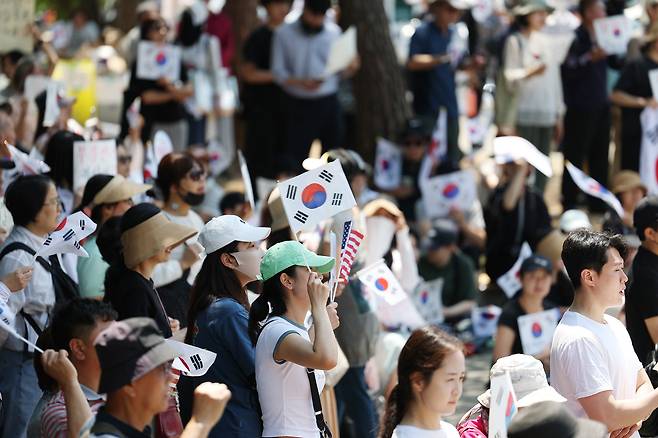 6·3 지방선거 투표용지 부족 사태를 규탄하며 재선거를 요구하는 '잠실 개표소 봉쇄 시위'가 계속되고 있는 9일 서울 송파구 올림픽공원 핸드볼경기장에서 한 참가자가 태극기를 흔들고 있다./연합뉴스