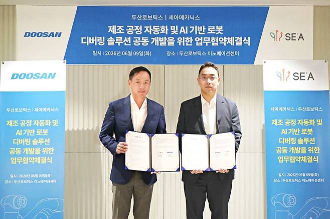 박인원 두산로보틱스 대표(왼쪽)가 지난 9일 성남시 분당구 소재 두산로보틱스 이노베이션 센터에서 이성욱 세아메카닉스 대표와 '제조 공정 자동화 및 AI 기반 로봇 디버링 솔루션 공동 개발'을 위한 업무협약(MOU)을 체결한 뒤 기념촬영을 하고 있다. 두산로보틱스 제공