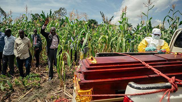 7일(현지시간) 민주콩고 북동부 부니아주 이투리에서 에볼라 사망자의 장례식이 진행되고 있다. 방호복을 입은 콩고적십자 관계자가 차에 관을 싣는 가운데 목사가 손을 들고 기도하고 있다. 연합뉴스