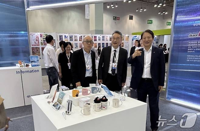 (왼쪽부터) 나건 부산시 총괄디자이너, 강필현 부산디자인진흥원 원장, 성희엽 부산시 미래혁신부시장이 '부산바다위' 부스를 방문한 모습 2026.6.11 ⓒ 뉴스1 홍윤 기자