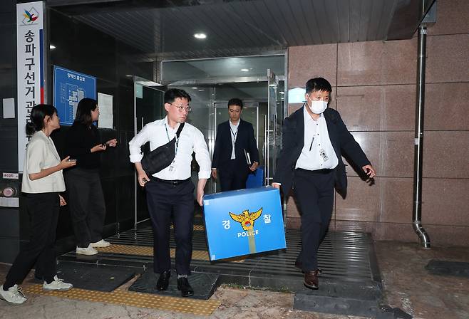 6·3 지방선거 투표용지 부족 사태를 수사 중인 검·경 합동수사본부 관계자들이 11일 서울 송파구선거관리위원회에서 압수수색을 마친 뒤 나서고 있다. /연합뉴스