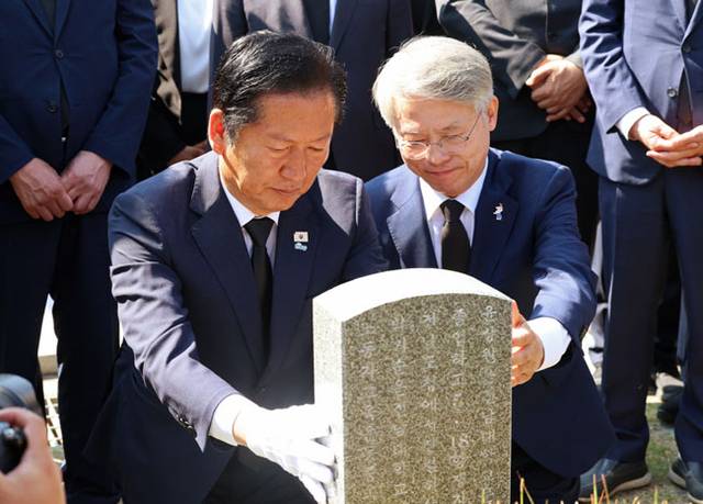 정청래(왼쪽) 더불어민주당 대표가 12일 오전 광주 북구 국립 5·18 민주묘지를 찾아 민형배 전남광주시장 당선인과 함께 고 윤상원 열사 묘소에 참배하며 묘비를 만지고 있다. 연합뉴스