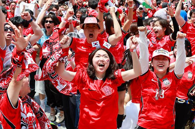 축구국가대표팀 공식 서포터즈 붉은악마를 비롯한 시민들이 12일 서울 종로구 광화문광장에서 2026 북중미월드컵 A조 조별리그 1차전 대한민국과 체코의 경기 후반전을 화면으로 지켜보며 거리응원을 펼치던 중 황인범의 동점골에 환호하고 있다.뉴스1